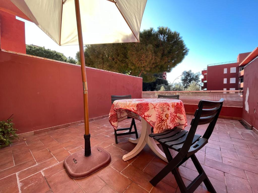 a table and chair with an umbrella on a patio at Appartamento Fiore in Follonica