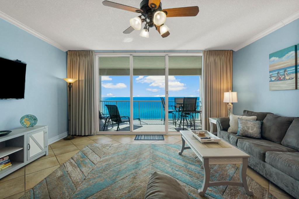 a living room with a couch and a ceiling fan at Palazzo #505 by Nautical Properties in Panama City Beach