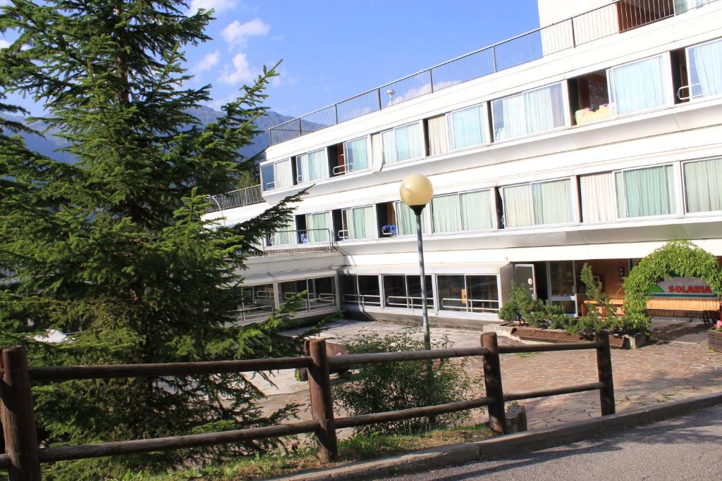 a white building with a fence in front of it at Residence Albarè in Mezzana