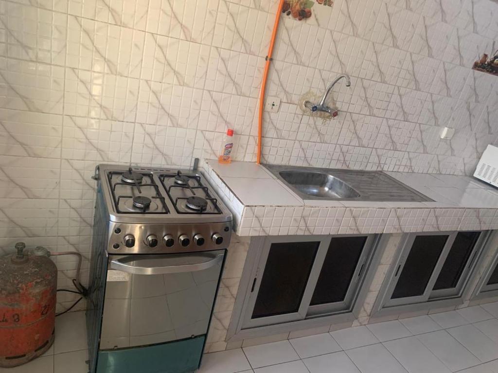 a kitchen with a stove and a sink at Appartement chambre meublée N 2 in Dakar
