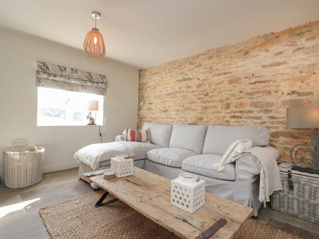 un soggiorno con divano bianco e parete di mattoni di The Barn a York