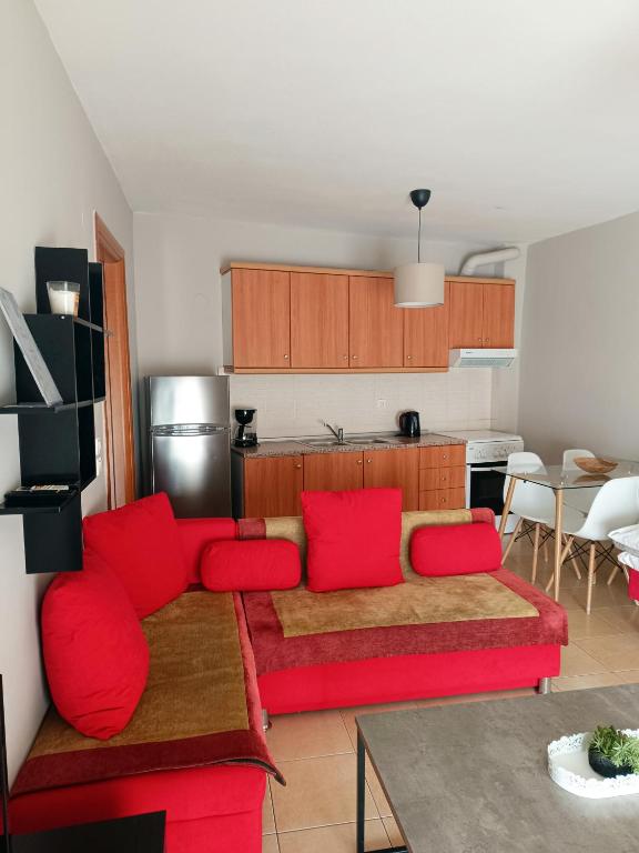 a living room with a red couch and a kitchen at Kalvou Flat2 in Thessaloniki