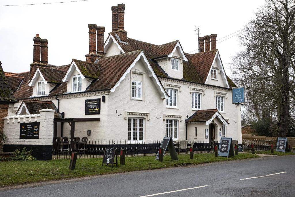 a large white house with signs in front of it at The Kings Head Country Hotel in Great Bircham