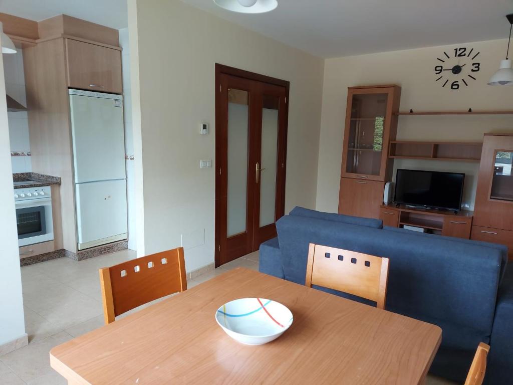 een woonkamer met een tafel en een blauwe bank bij Apartamento Don Manuel 2 in Cuntis