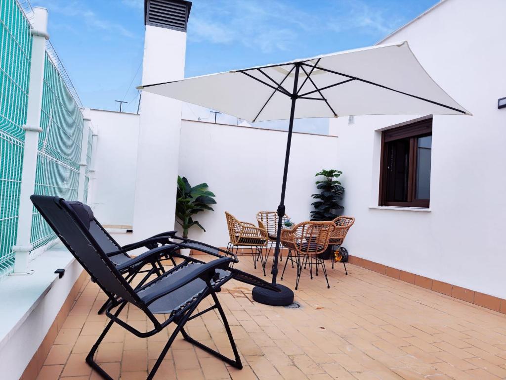 un patio con una silla y una sombrilla en el balcón en La Terraza de Lulú Little Apartments en Cádiz