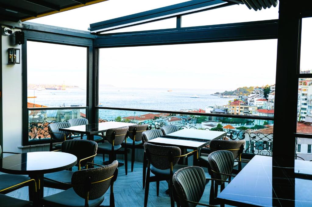 a restaurant with tables and chairs and a view of the ocean at Sing Of Hotel & Suites Taksim Istanbul in Istanbul