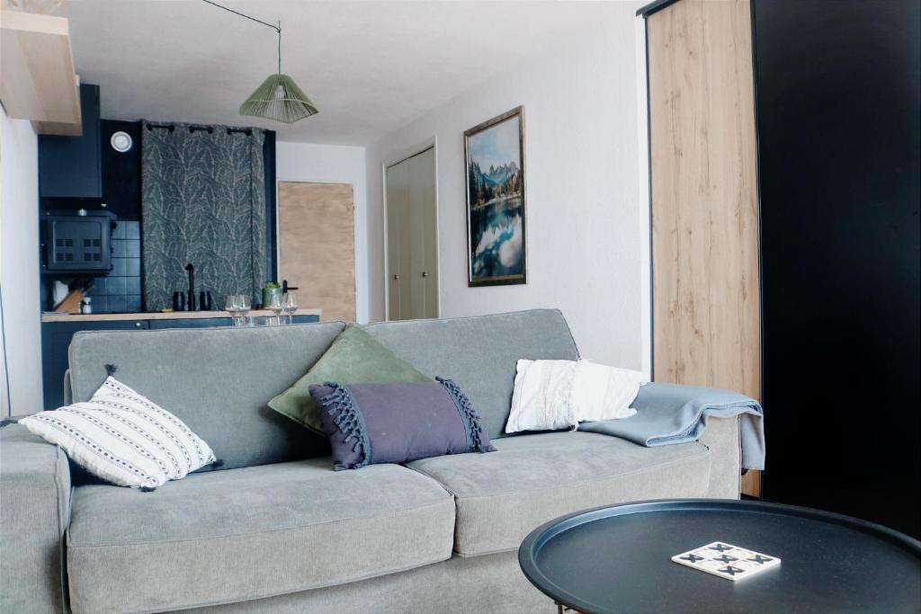 a living room with a couch and a table at Charmant Appartement Les temples du Soleil in Font-Romeu-Odeillo-Via