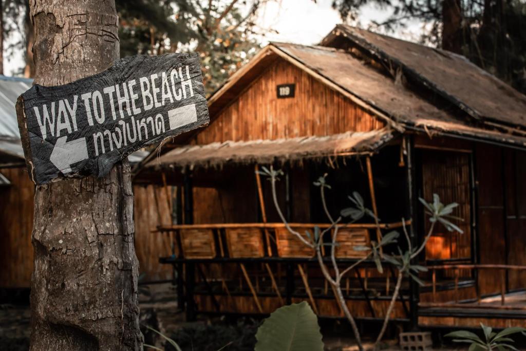 a wooden way to the beach sign on a tree at Eco Lanta Hideaway Beach Resort in Ko Lanta