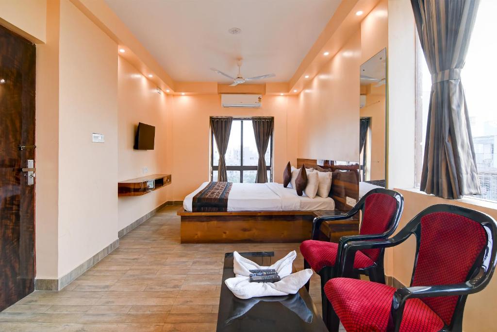 Eco Corporate Inn 2 Rajarhat في kolkata: غرفه فندقيه بسرير وكرسيين