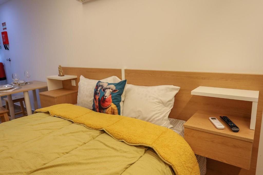 um quarto com uma cama com um cobertor amarelo em CASA ORIGENS ll em Seia