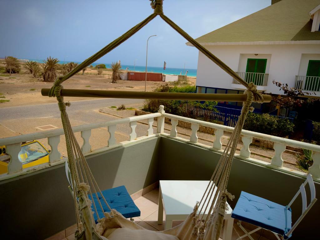 um alpendre com 2 cadeiras e um baloiço em Wind - Apartments close to the beach em Santa Maria
