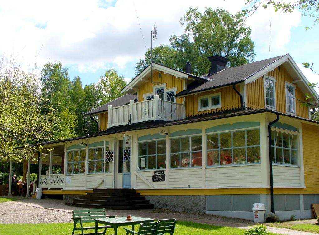 a large yellow house with a table in front of it at Sofielund Vandrarhem & Camping in Sala