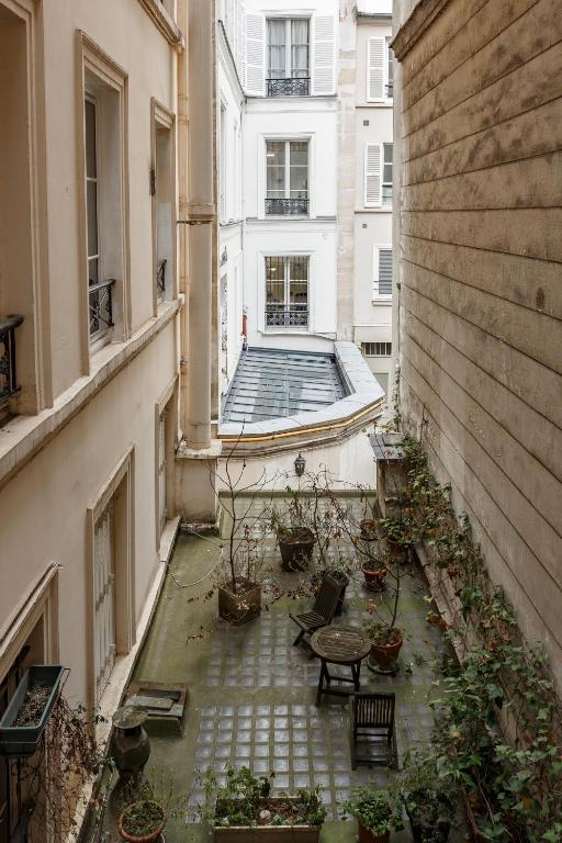 une allée avec une table et des chaises dans un bâtiment dans l'établissement Stylish apartment in the heart of Paris, à Paris