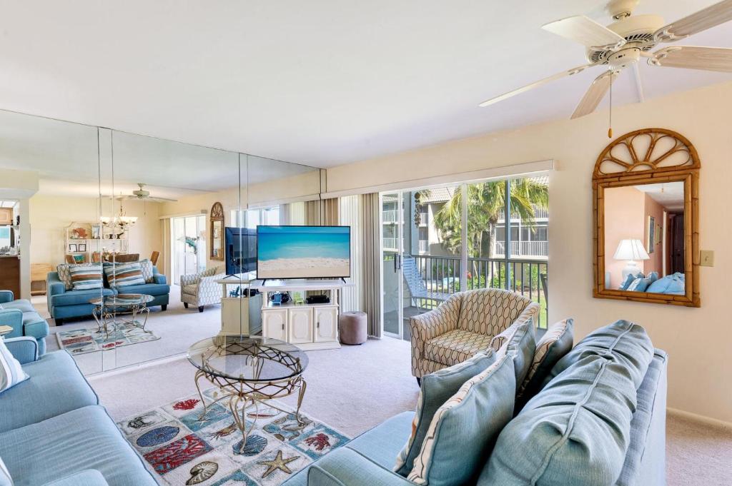 uma sala de estar com um sofá azul e uma televisão em Sanibel Siesta on the Beach unit 501 condo em Sanibel