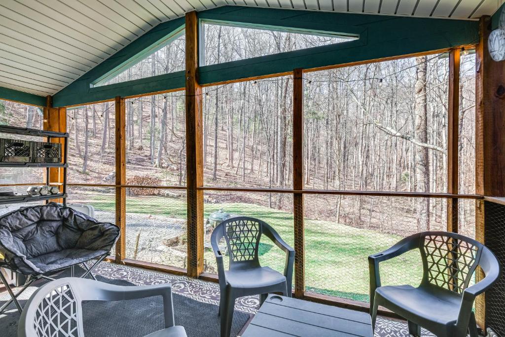 a screened in porch with two chairs and a table at Pet-Friendly Roanoke Home with Fire Pit and Grill! in Roanoke