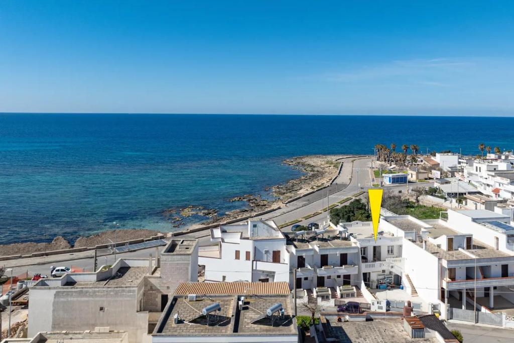 an aerial view of a beach with white buildings and the ocean at Camere arcobaleno fronte mare a Torre san Giovanni in Torre San Giovanni Ugento