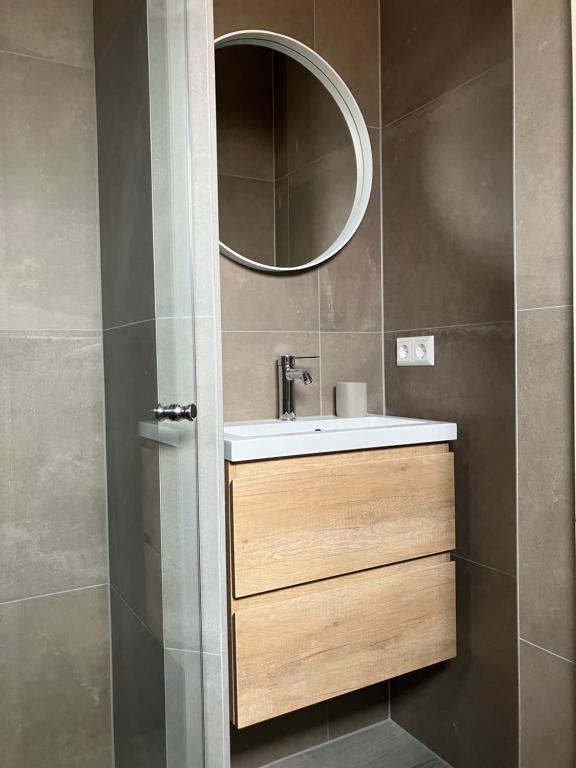een badkamer met een wastafel en een spiegel bij Bundi Beach in Egmond aan Zee