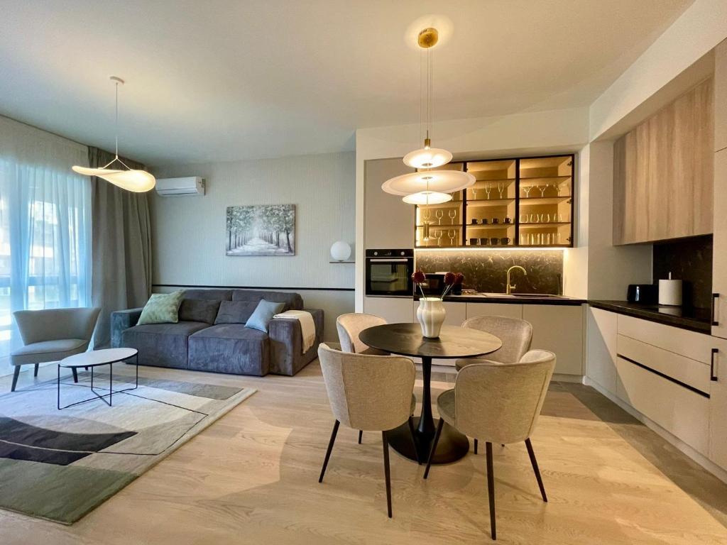 a kitchen and living room with a table and chairs at Aglaya 3 - Luxury 2BR Apartment in Belgrade