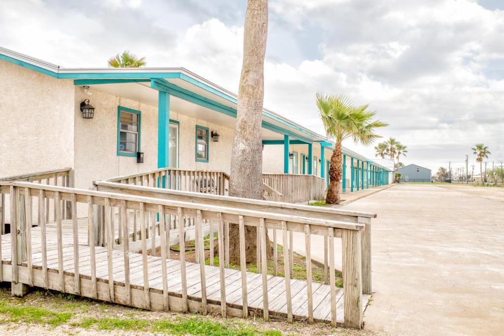 un edificio con una valla y palmeras en captain's quarters, en Port O'Connor