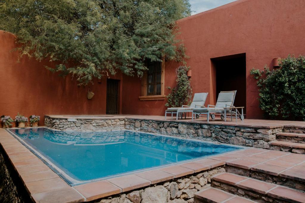 a swimming pool in a yard next to a building at Hotel Casa De Quino in Querétaro