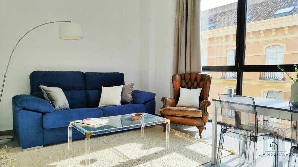 a living room with a blue couch and a chair at Living4malaga Victoria Center Apartment in Málaga