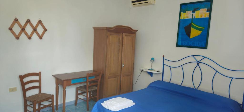 a bedroom with a bed and a table and a desk at Piccolo Tirreno Hotel Residence in Procida