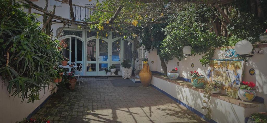 un patio con plantas y jarrones en un edificio en Piccolo Tirreno Hotel Residence, en Procida