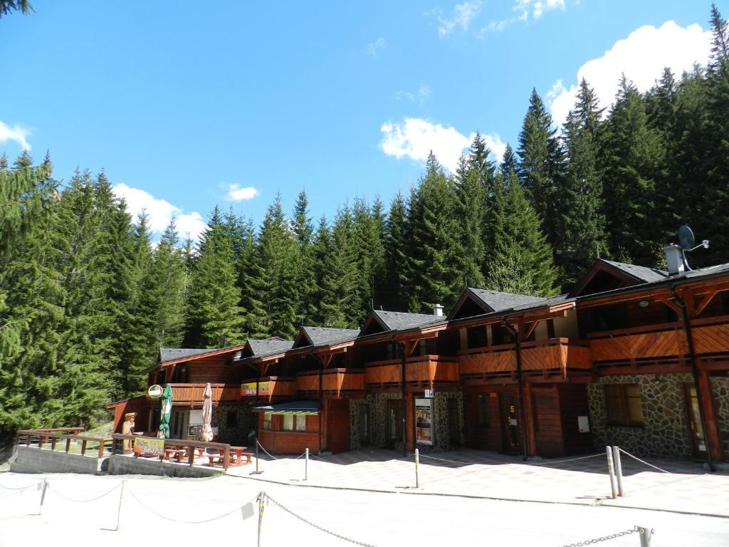 ein großes Holzgebäude mit Bäumen im Hintergrund in der Unterkunft Apartmány Jasná, Biela Púť in Demänovská Dolina