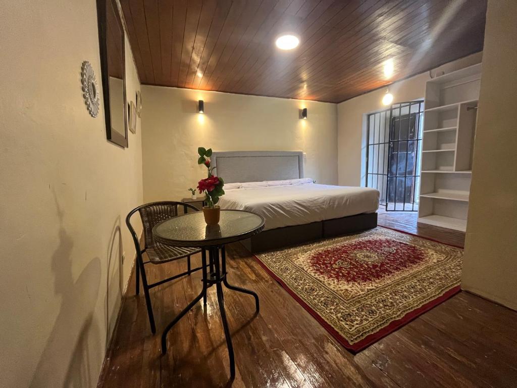 a small bedroom with a bed and a table and a rug at Casa Virgen del Carmen in Cusco