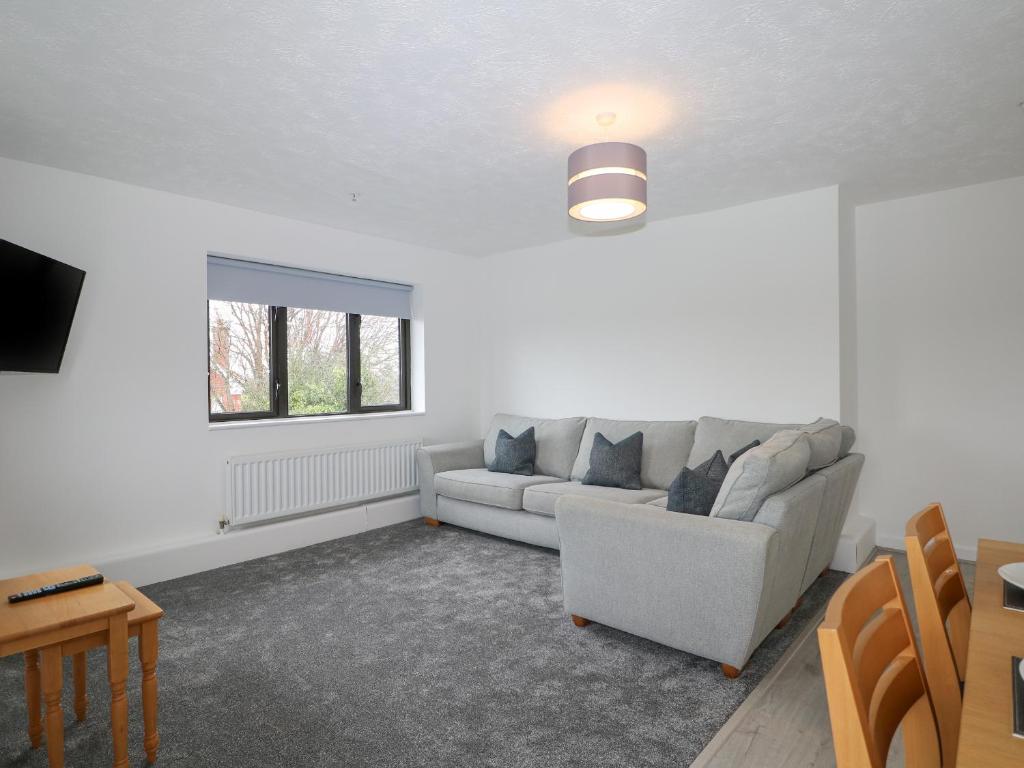 ein Wohnzimmer mit einem Sofa und einem Fenster in der Unterkunft Flat 32 - Marine Court in Littlehampton