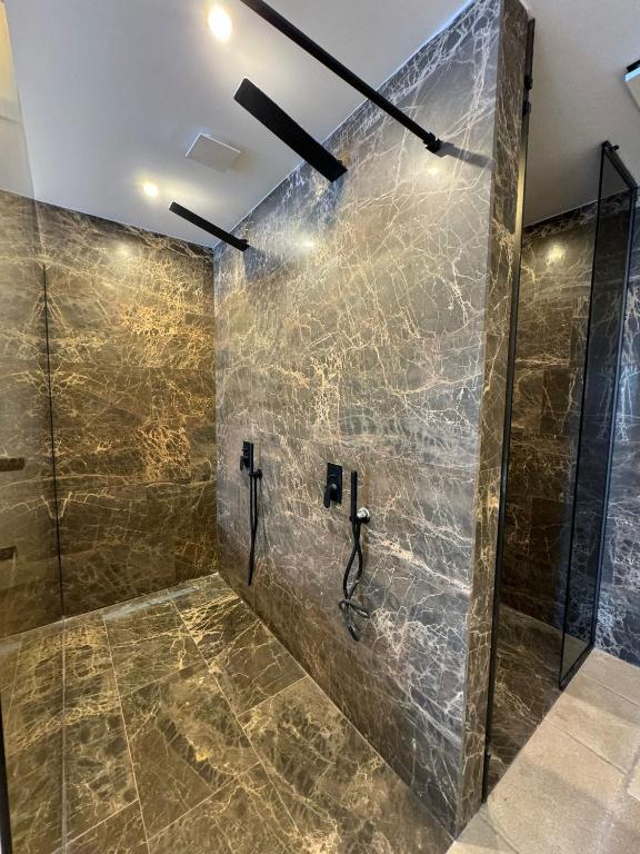 bagno con doccia e piastrelle in marmo di Al Capri Suite Isola di Capri a Capri