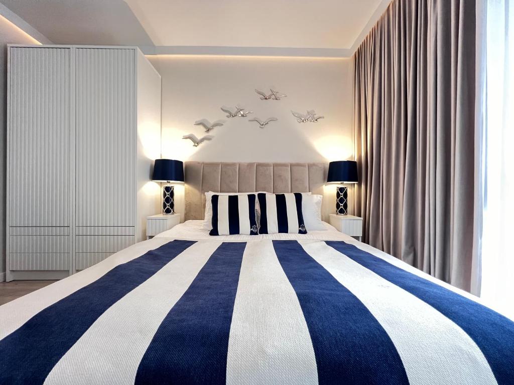 a bedroom with a large bed with blue and white stripes at Baltic Line Marina-Mewa in Gdańsk
