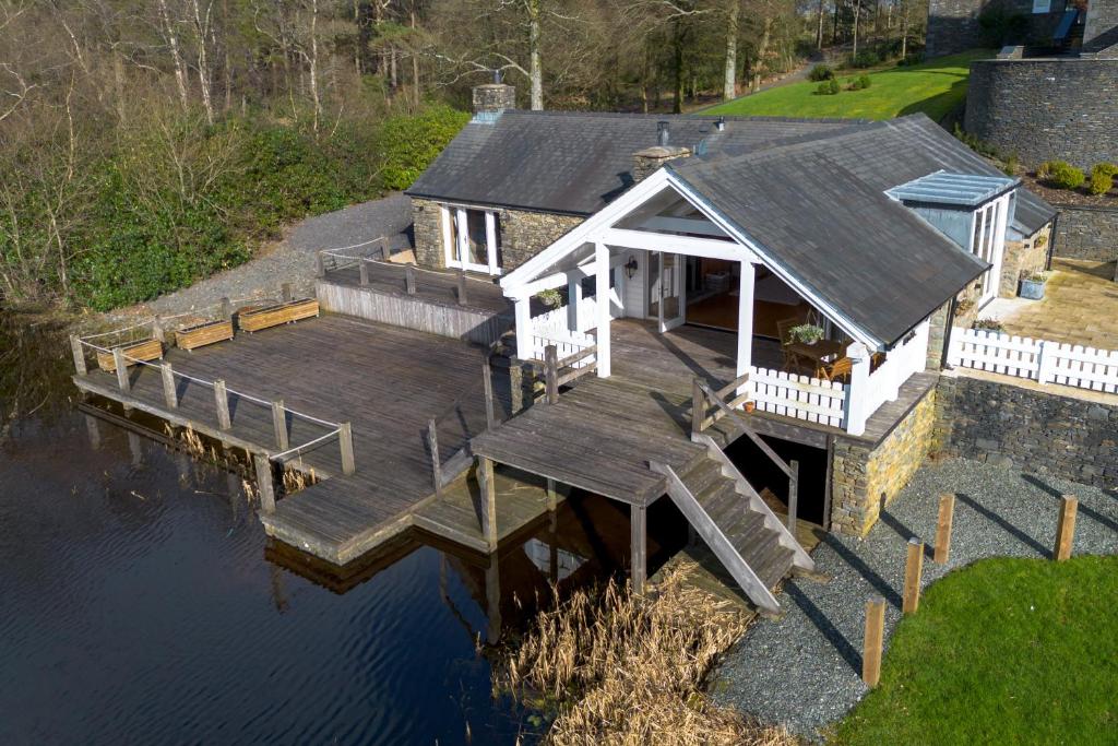 an aerial view of a house with a dock on the water at Lilymere Boat House in Sedbergh