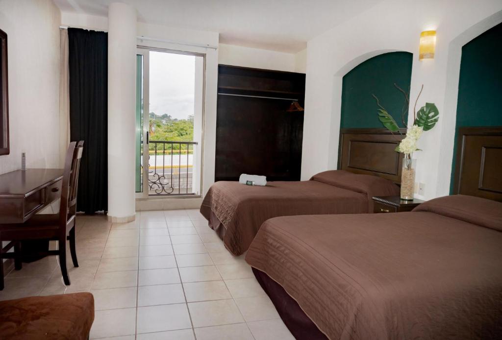 um quarto de hotel com duas camas e uma secretária e uma janela em Hotel Du Parc em Poza Rica de Hidalgo