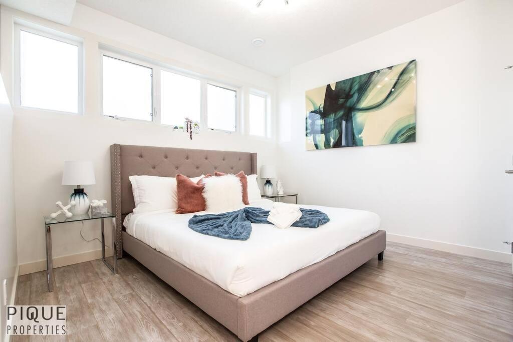 1 dormitorio con 1 cama grande con sábanas blancas en Spacious Modern Suite - King Bed - Central - WiFi! en Edmonton
