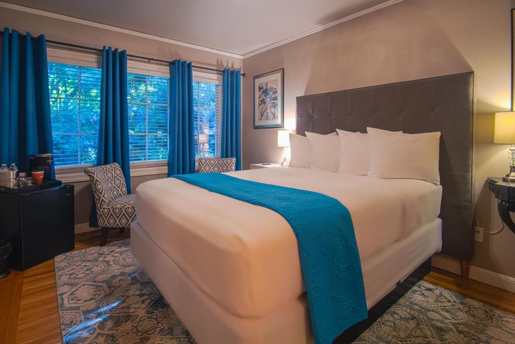 a bedroom with a large bed with a blue blanket at Inn at Parkside in Sacramento