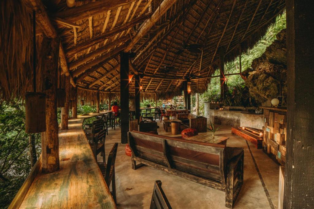a restaurant with wooden tables and chairs and a wooden roof at ZÂRIA Hotel & Retreat Center in El Valle