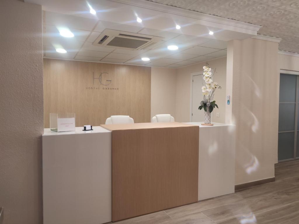 an office with a reception desk with white chairs at Hostal Garamar in Benicàssim