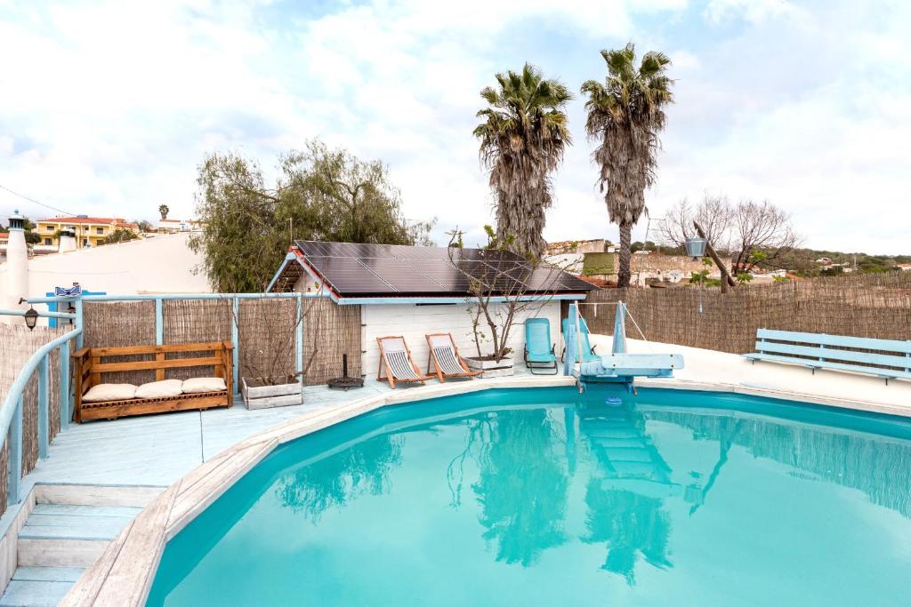 uma piscina com cadeiras e palmeiras em Algarve, Quinta Estacao Alcantarilha - Casa 1 em Alcantarilha