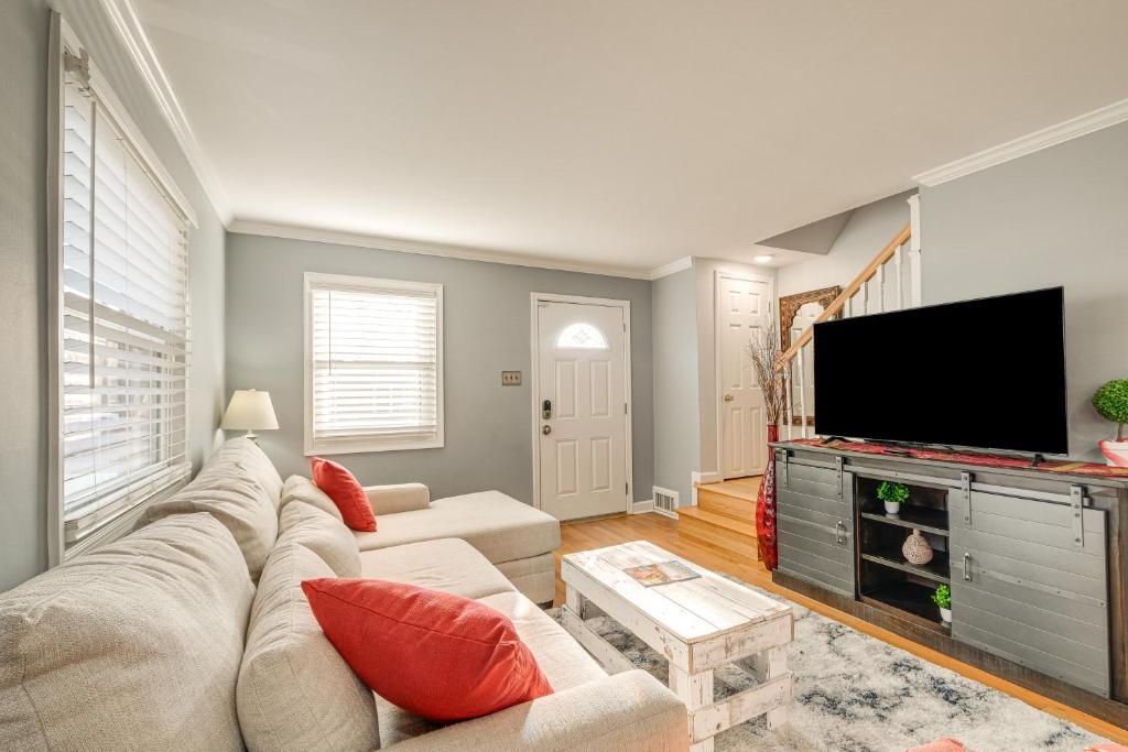 a living room with a couch and a flat screen tv at Pet-Friendly Alexandria Escape with Yard 8 Mi to DC in Alexandria