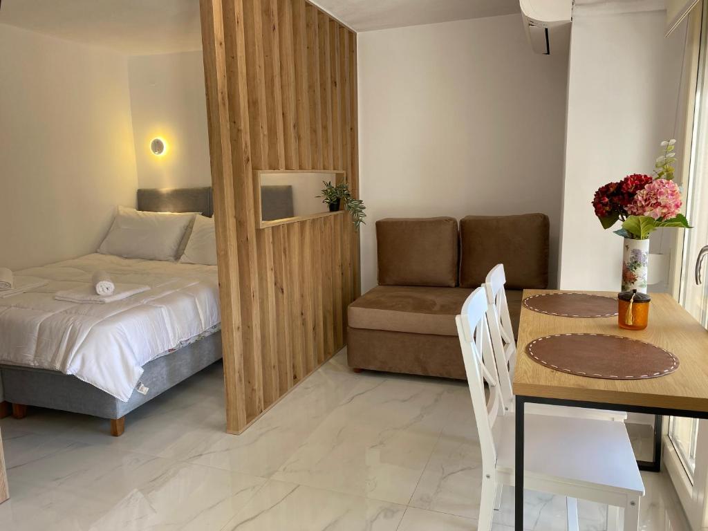 a bedroom with a bed and a table and a chair at White Apartment in Kavala