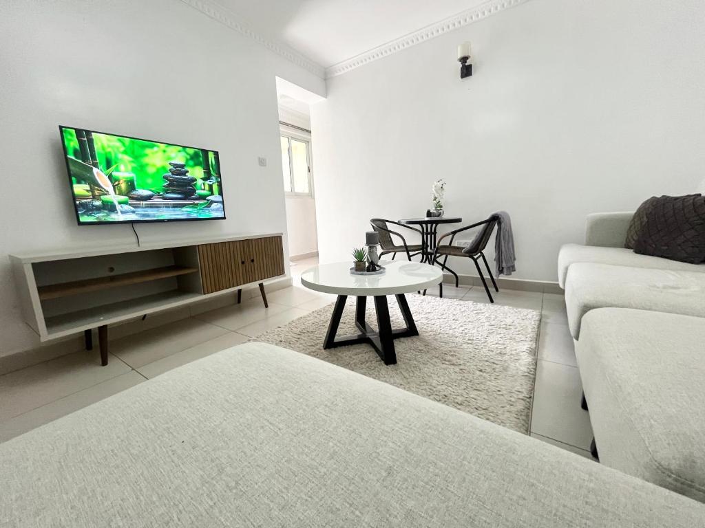 uma sala de estar com um sofá e uma televisão na parede em Neema Executive Suites Ngong RD with Balcony em Nairobi
