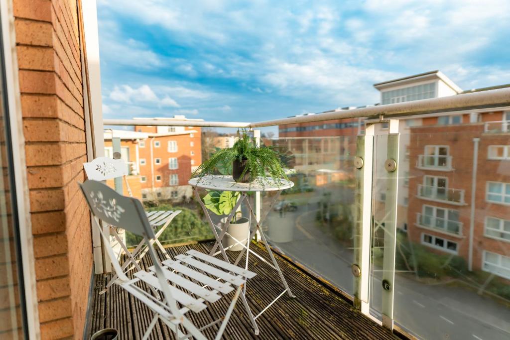 a balcony with chairs and a table and a view of a city at The Bay Retreat in Cardiff