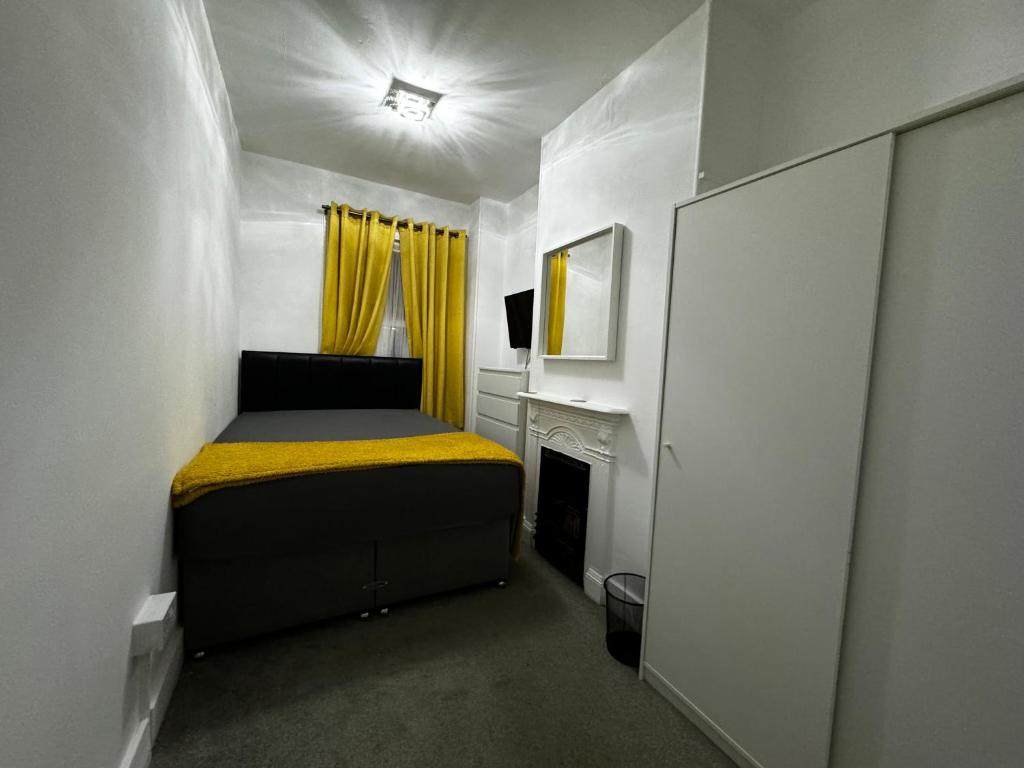 a small bedroom with a bed and a fireplace at Galaxy apartments Brentwood in Brentwood