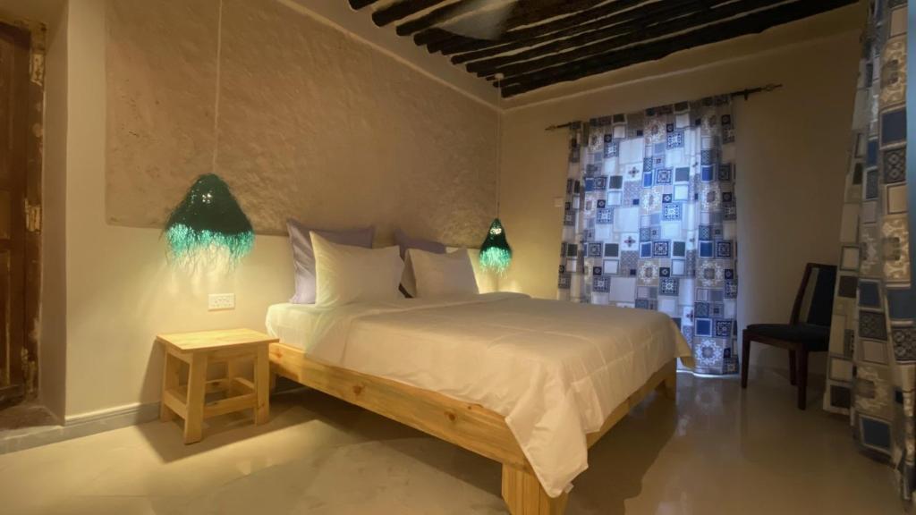 Schlafzimmer mit einem Bett und einem Fenster in der Unterkunft Hanaia House in Stone Town