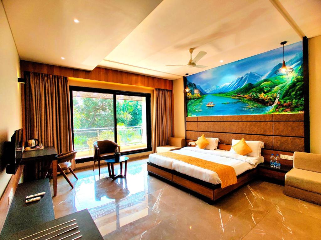 a bedroom with a large painting on the wall at Hotel Anil Farmhouse Gir Jungle Resort in Sasan Gir