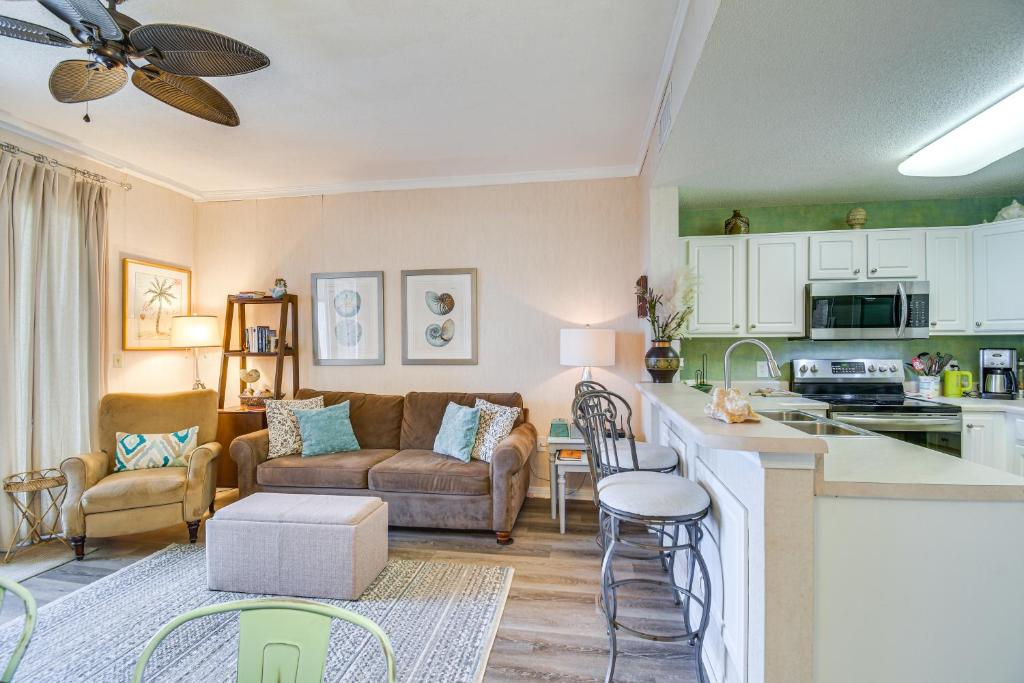 eine Küche und ein Wohnzimmer mit einer Couch und einem Tisch in der Unterkunft Gulf Shores Condo with Balcony 2 Mi to Fort Morgan! in Gulf Shores