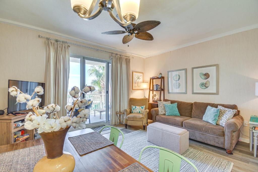 ein Wohnzimmer mit einer Couch und einem Tisch in der Unterkunft Gulf Shores Condo with Balcony 2 Mi to Fort Morgan! in Gulf Shores