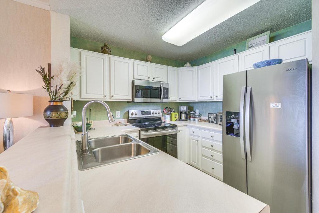 eine Küche mit weißen Schränken und einem Edelstahlkühlschrank in der Unterkunft Gulf Shores Condo with Balcony 2 Mi to Fort Morgan! in Gulf Shores