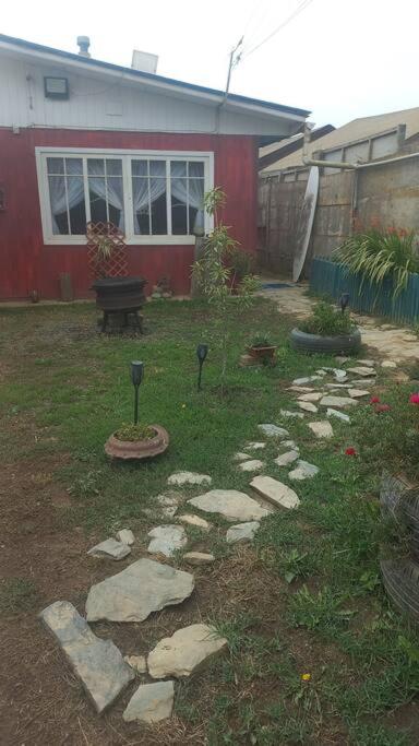 um jardim com pedras na relva ao lado de uma casa em Pichilemu, a 200mts de la playa. em Pichilemu